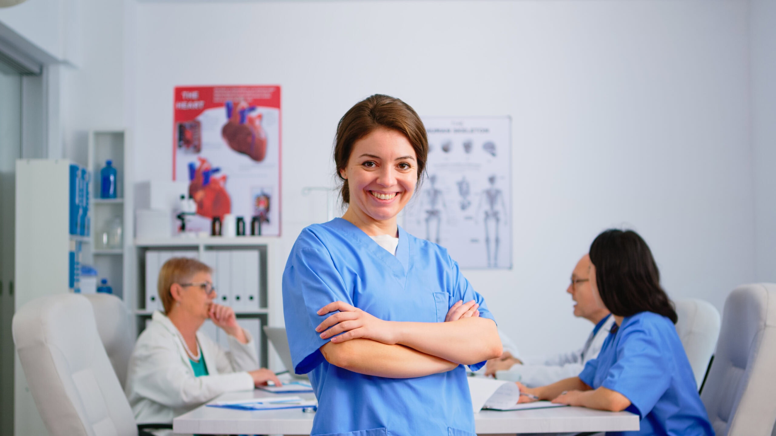 Portrait of young nurse standing in front of camera smiling